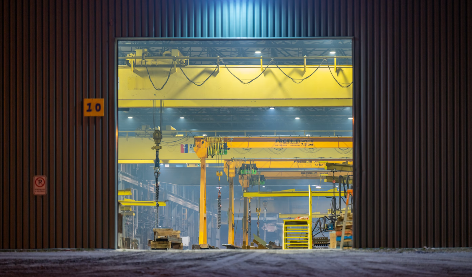 Image of the outside of a warehouse with large mechanical cranes for parts forecasting.