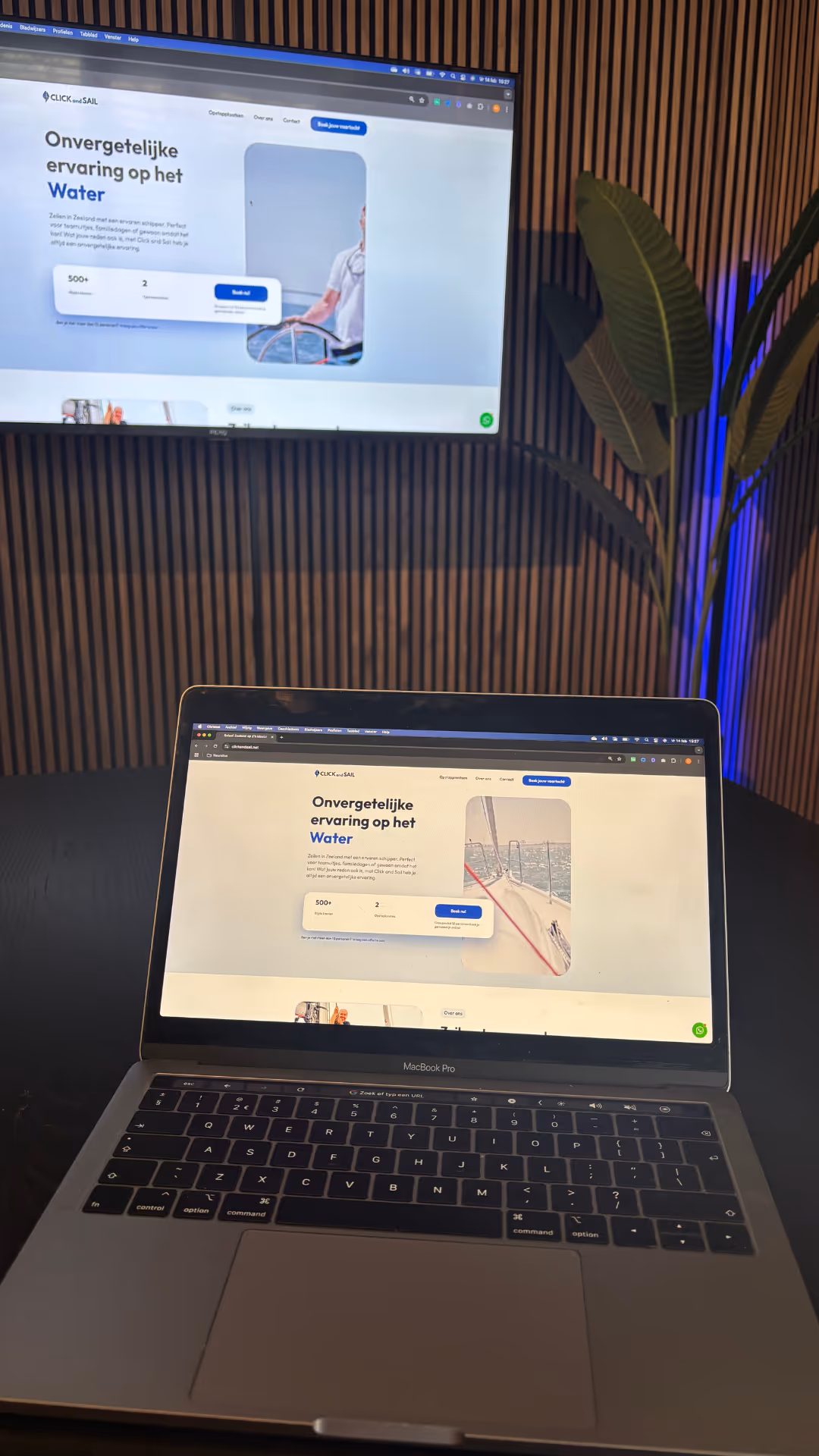 Foto van een laptop en een televisie, waar de website van Click and Sail te zien is.