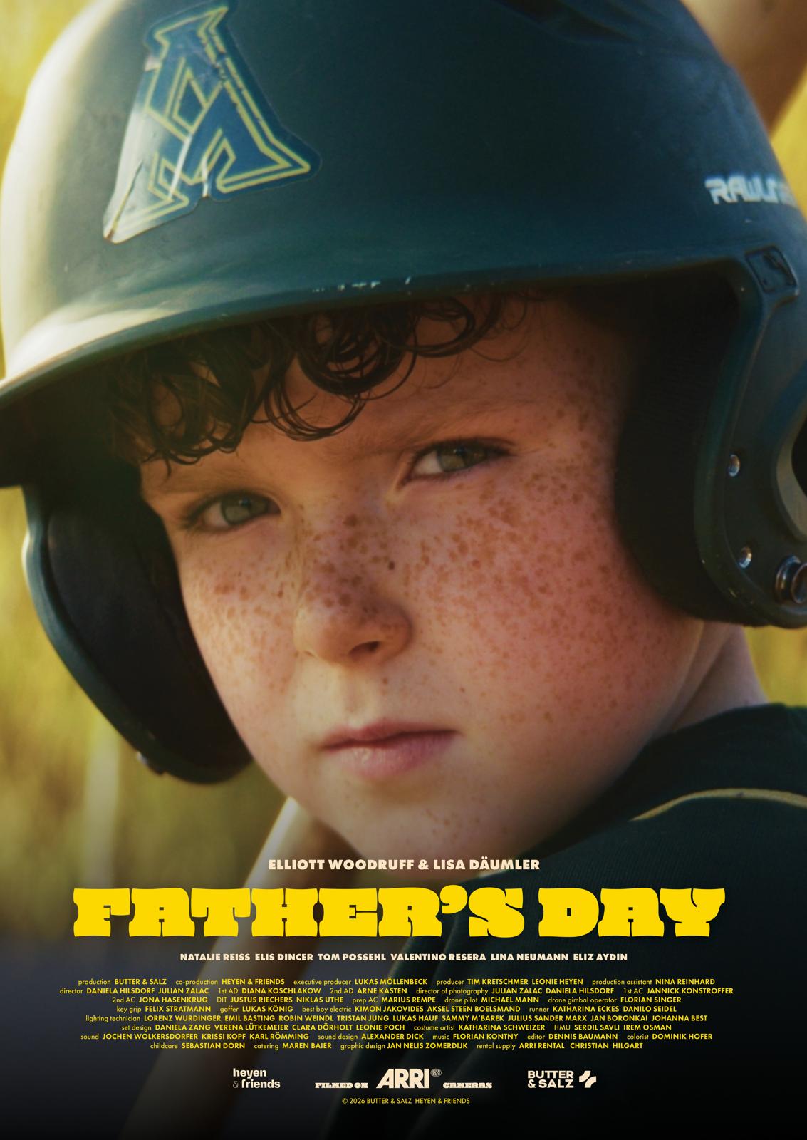 Portrait of a boy with curly hair in front of a chalkboard featuring the film title ‘Fathersday’ and the release date May 14, 2026.