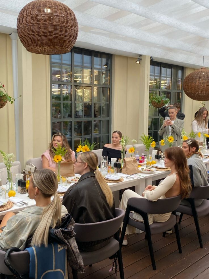 Women sharing a long brunch table with sunflowers at a wellness event