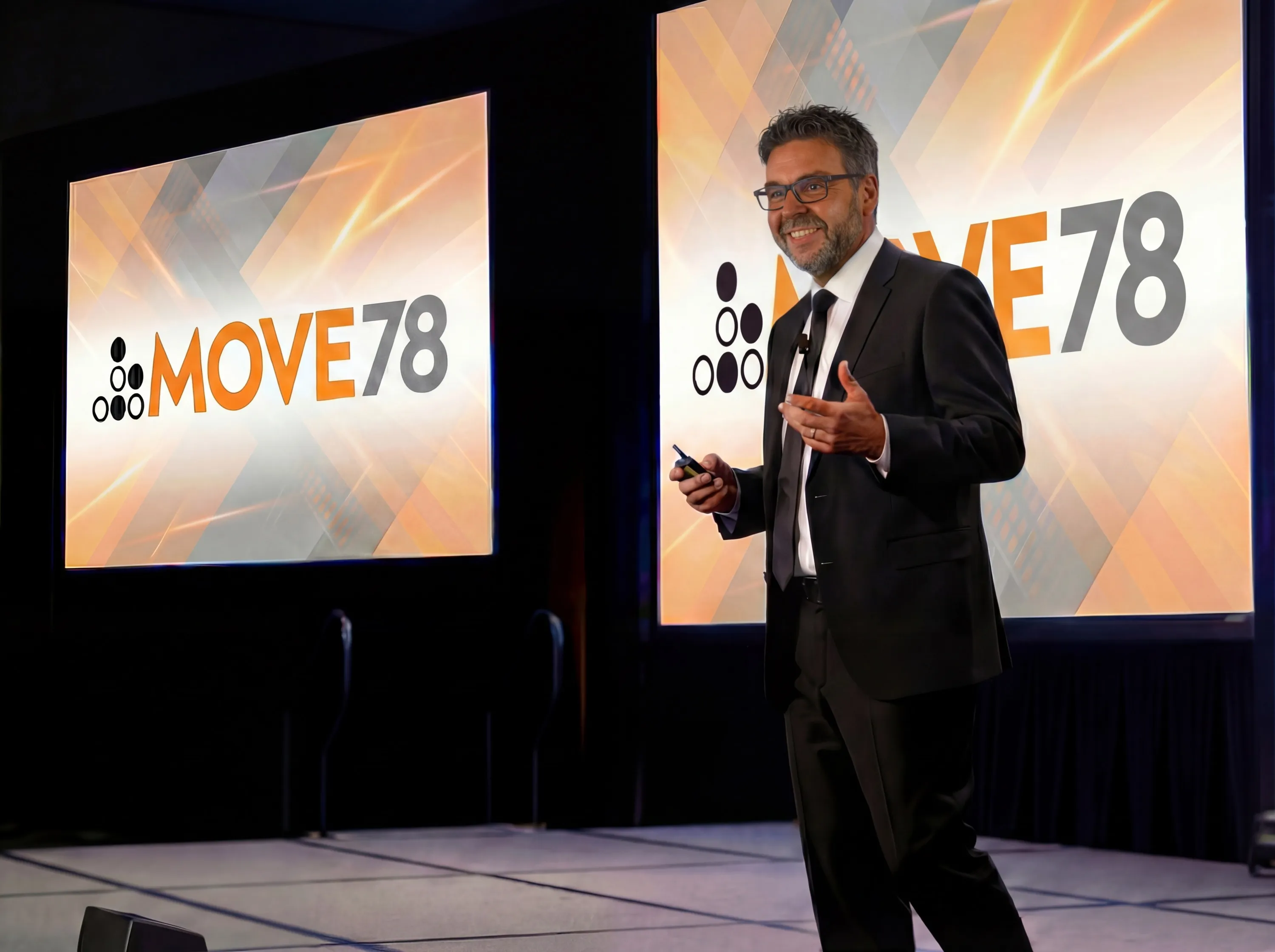Rick Pozniak presenting on stage at a conference, with Move78 branding on the screens behind him.