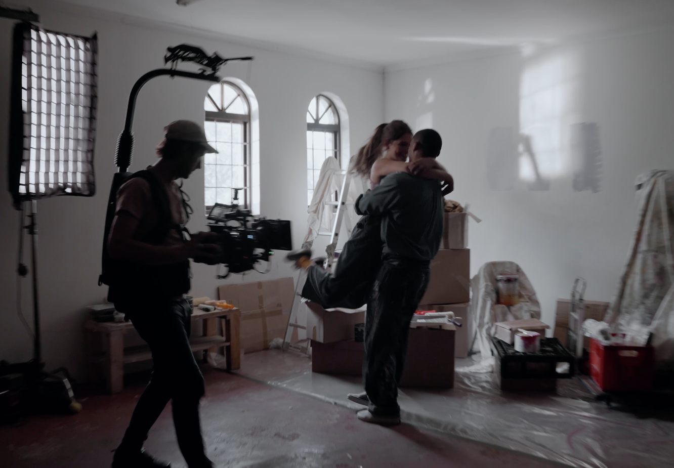 Film crew shooting a scene in a bright, sunlit room