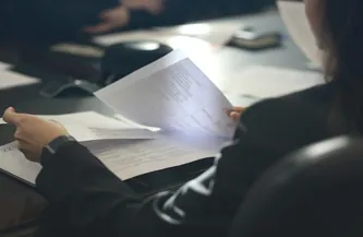 Clerc de notaire relisant un acte avant signature dans une étude notariale