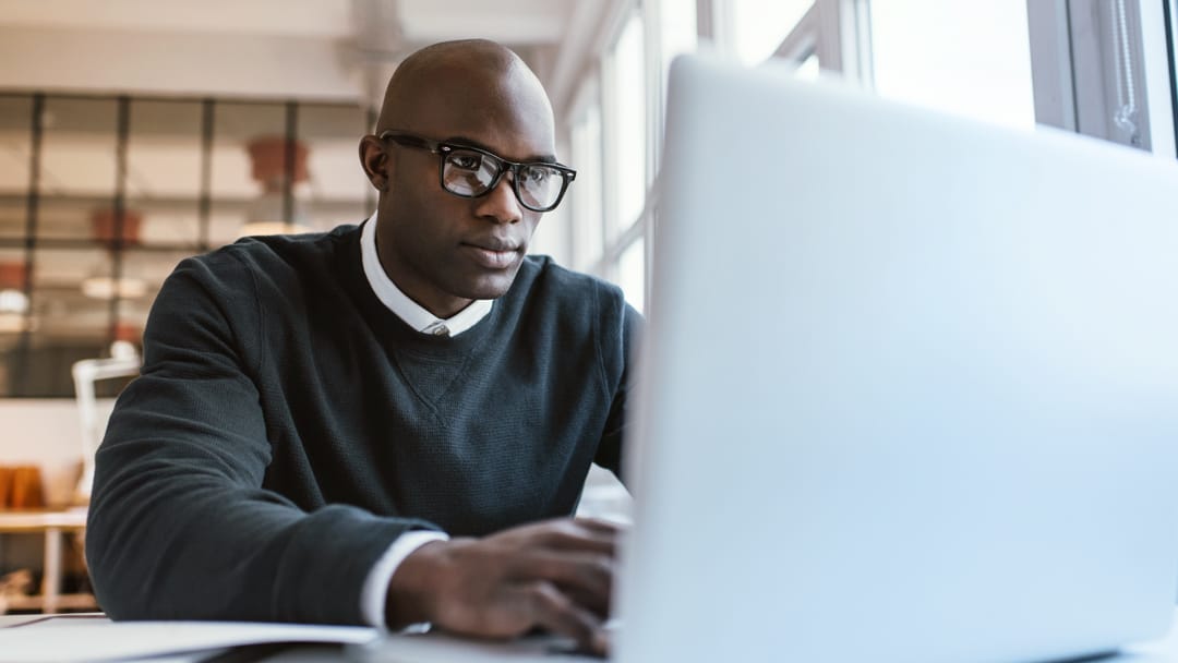 man with glasses working on a laptop - How to Dissolve a Business