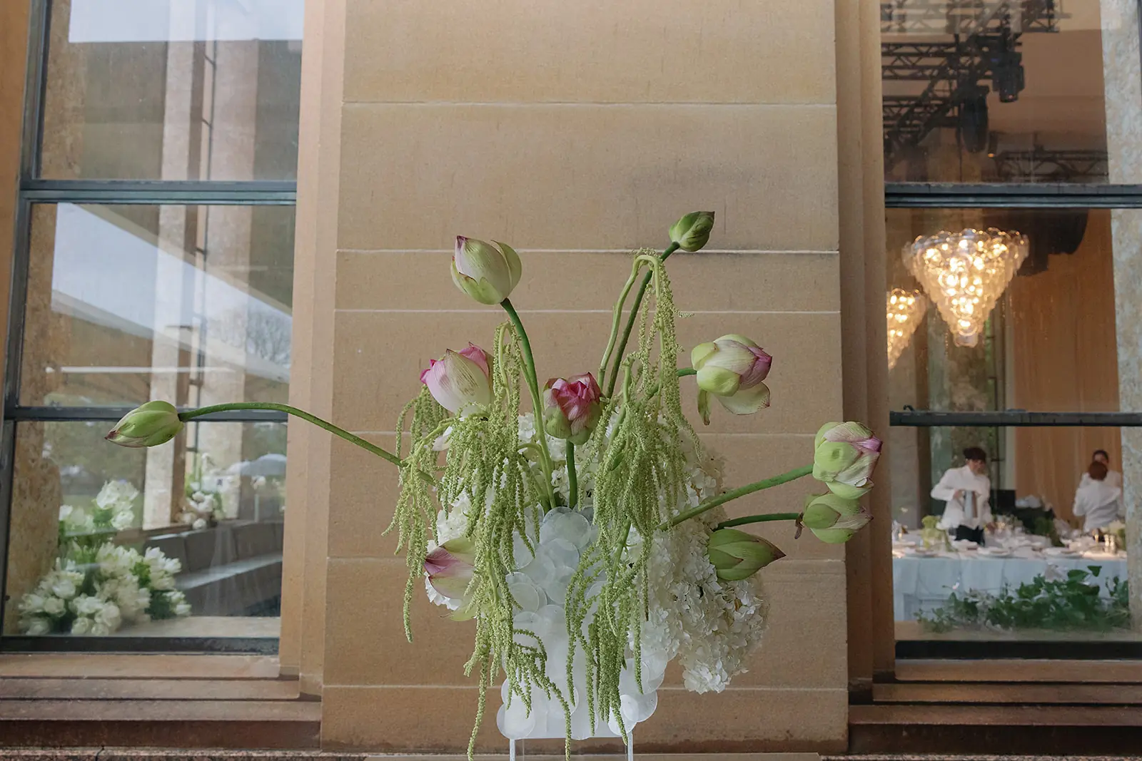 Just married couple holding hands walking through dining room at their wedding decorated by Mrs Gibbons Flowers