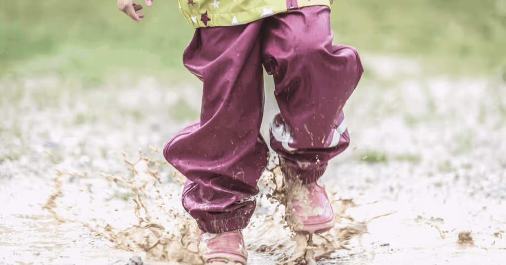 Child jumping in puddle