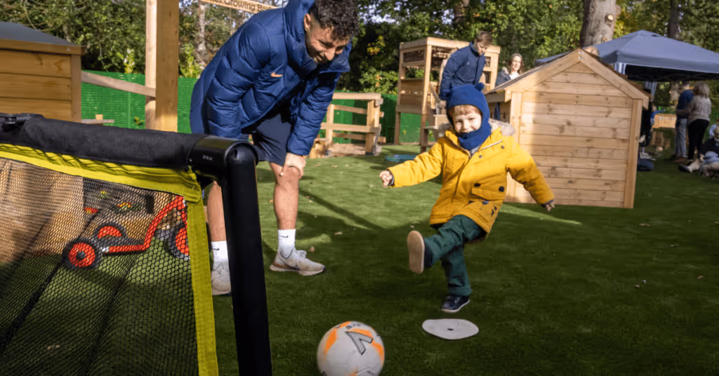 child kicking football at walton nursery