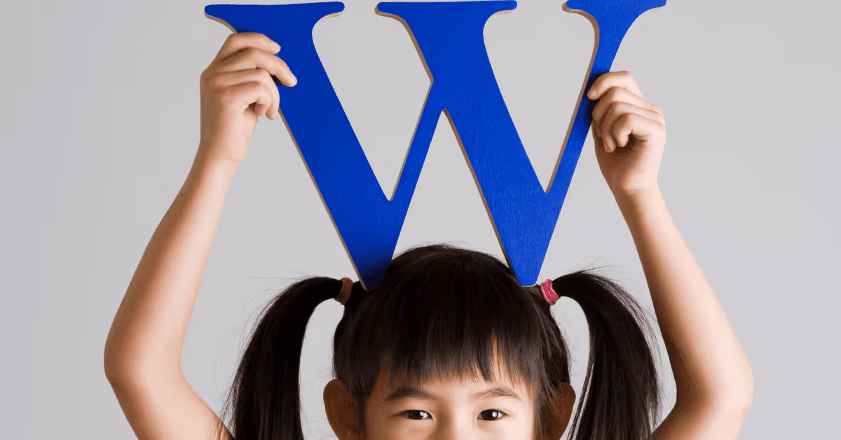 child holding letter W