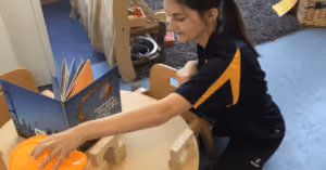 nursery room leader setting up children's activity