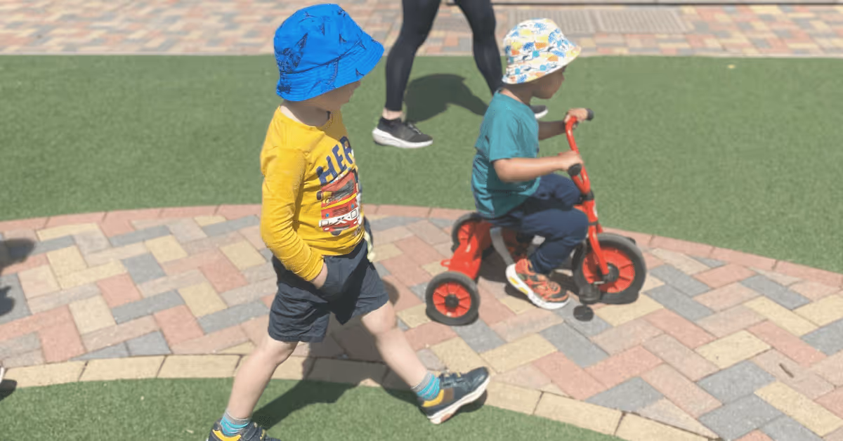 children riding bikes in garden at nursery