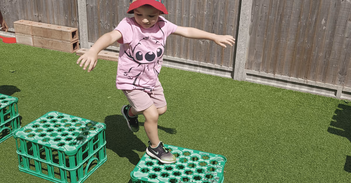 child jumping over obstacle course in nursery