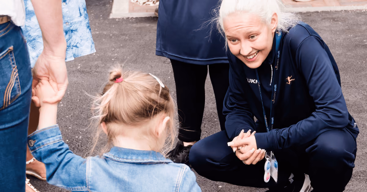 nursery practitioner smiling at child