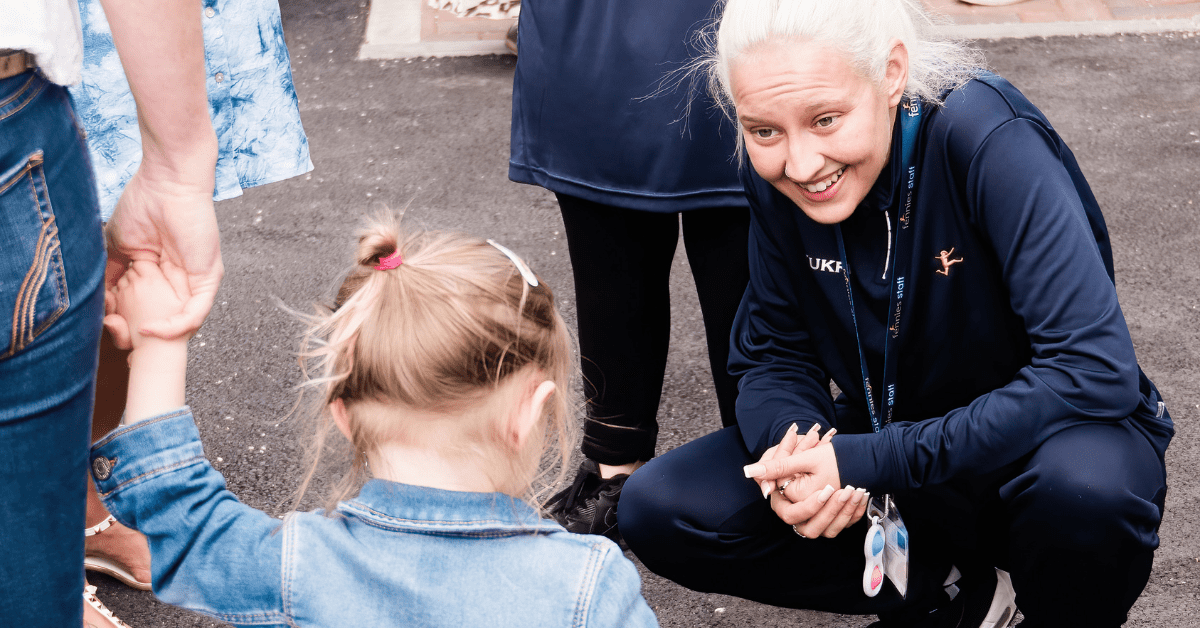 nursery practitioner smiling at child