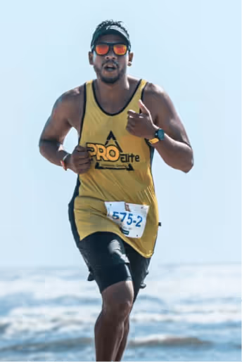 foto do treinador da pro elite assessoria correndo na praia