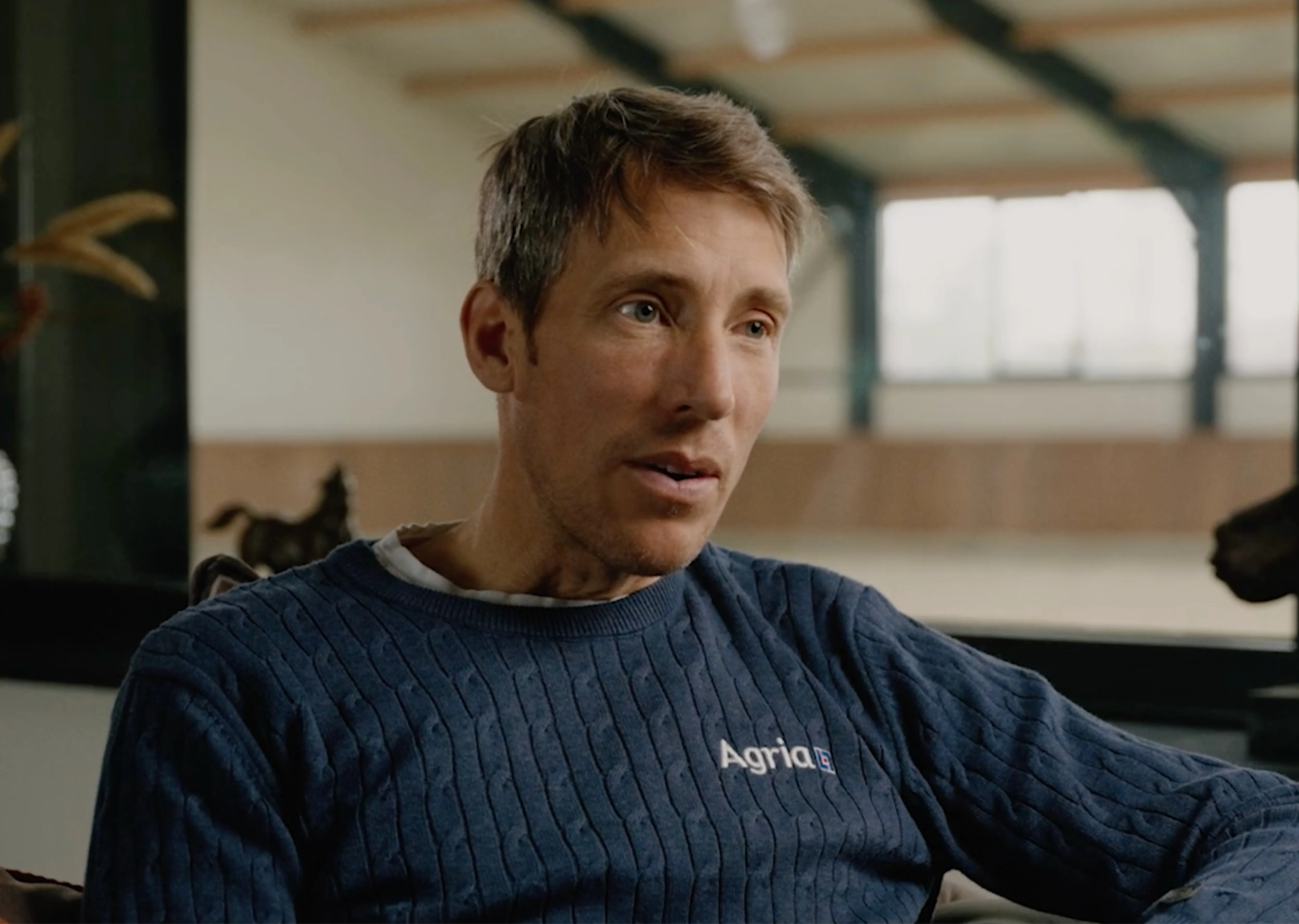 Two brushes in wood, with leather handles, stacked on top of a horse back, shot in a crispy clean photo studio.