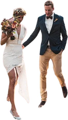 Bride in white dress holding a bouquet and groom in navy blazer and tan pants walking hand in hand.