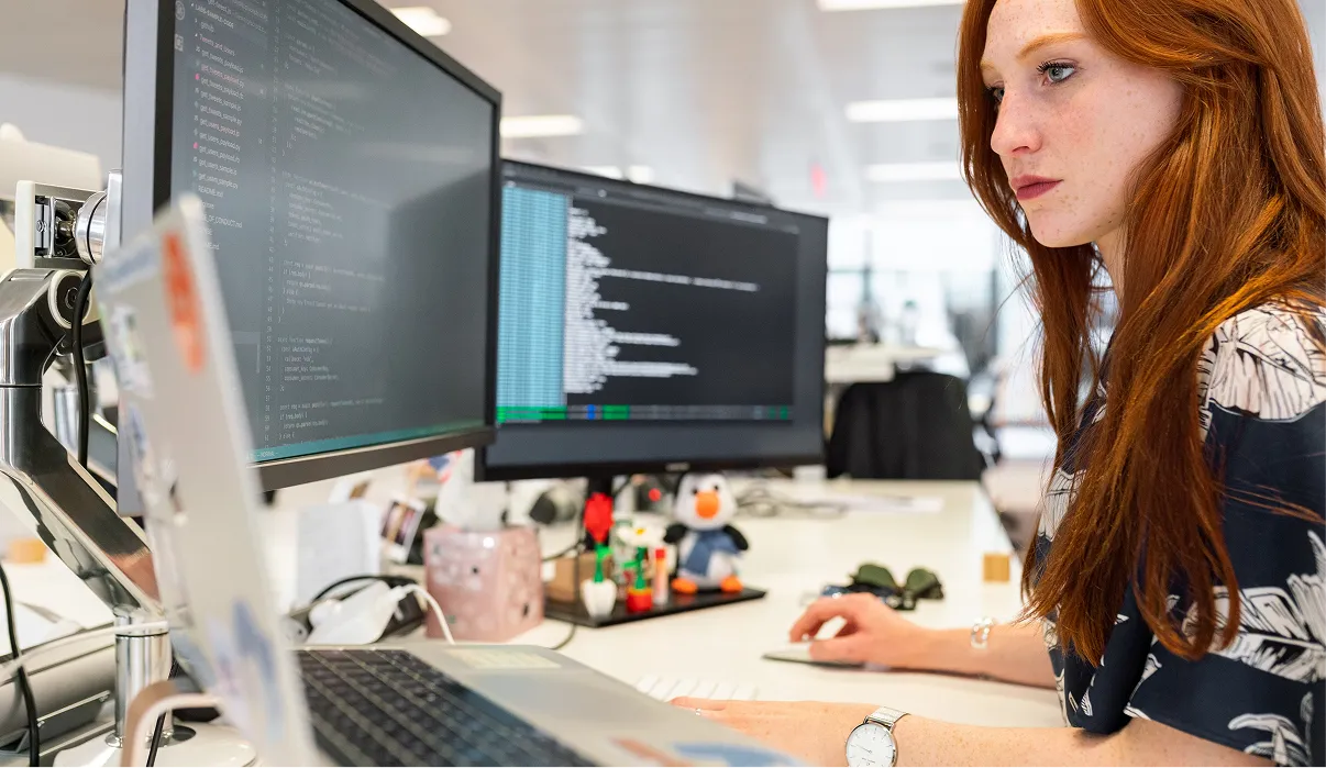 a woman doing something with laptop and computers