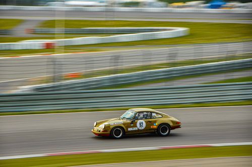 Green Porsche racing on a track.