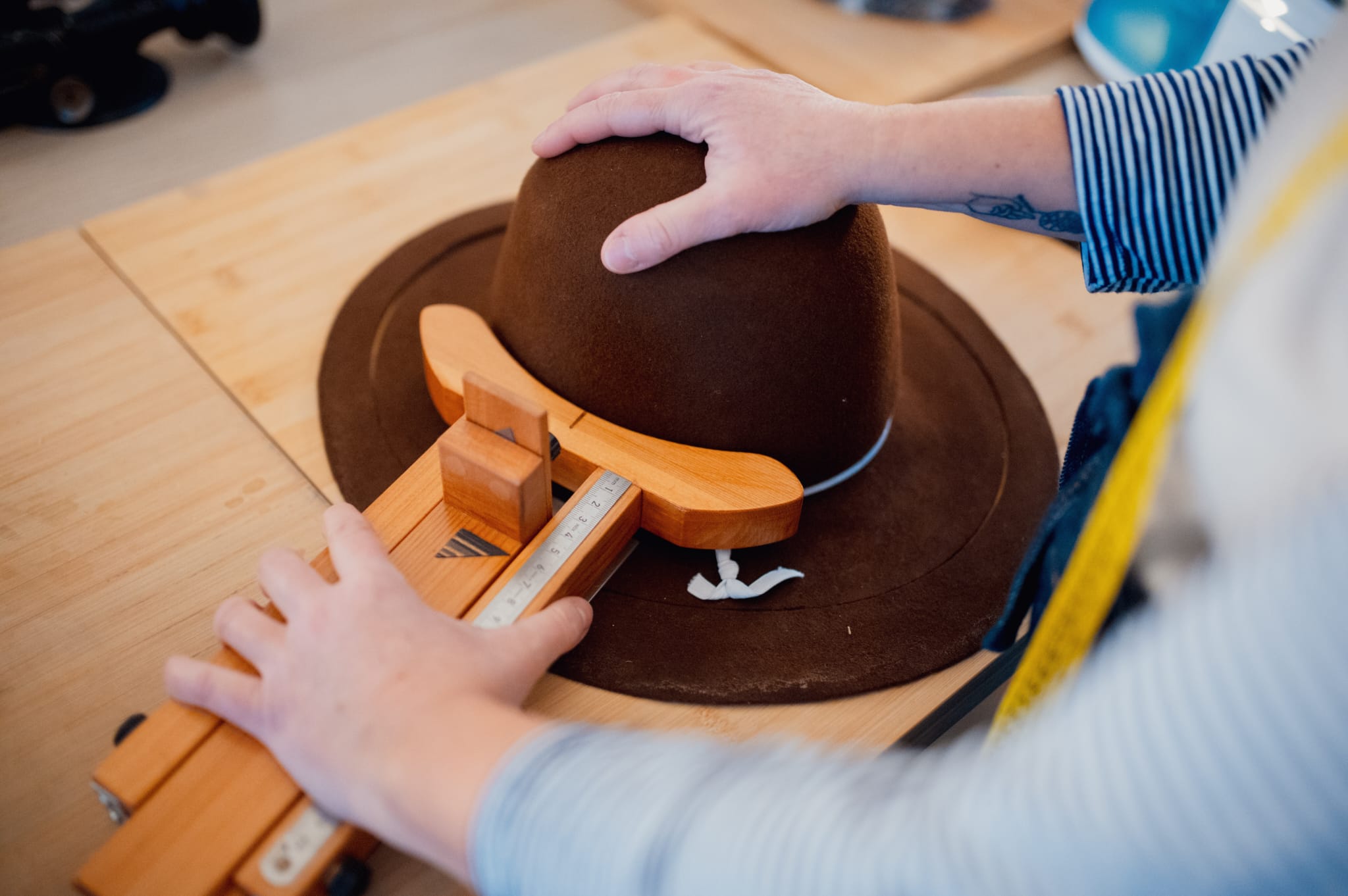 Cristina lavora ad un cappello fedora nel suo laboratorio