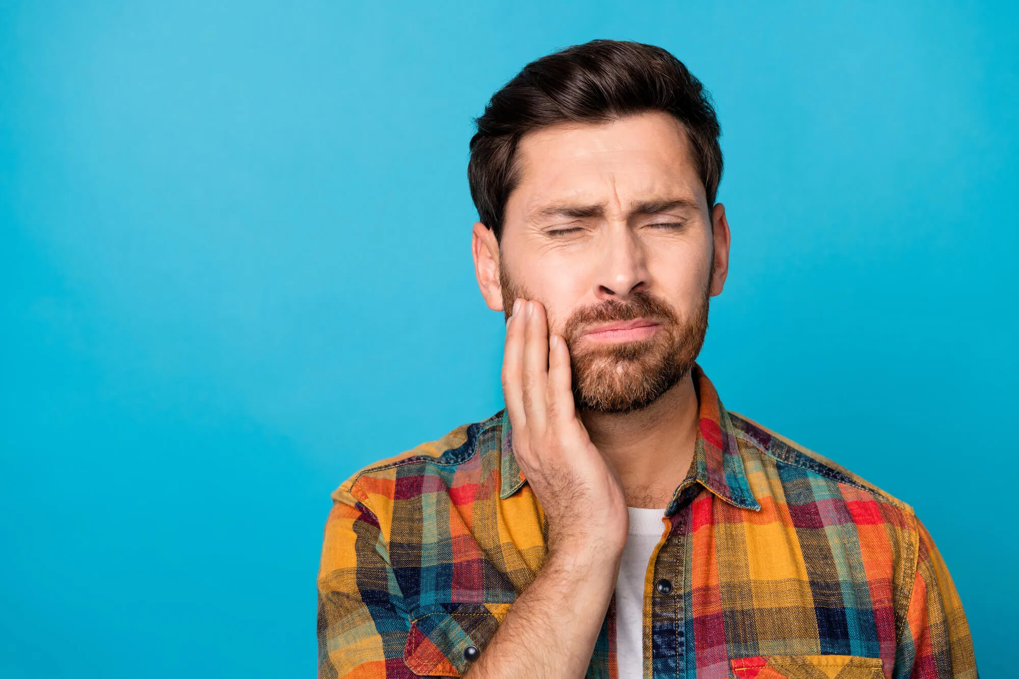 man in pain needs to see an emergency dentist greensboro nc