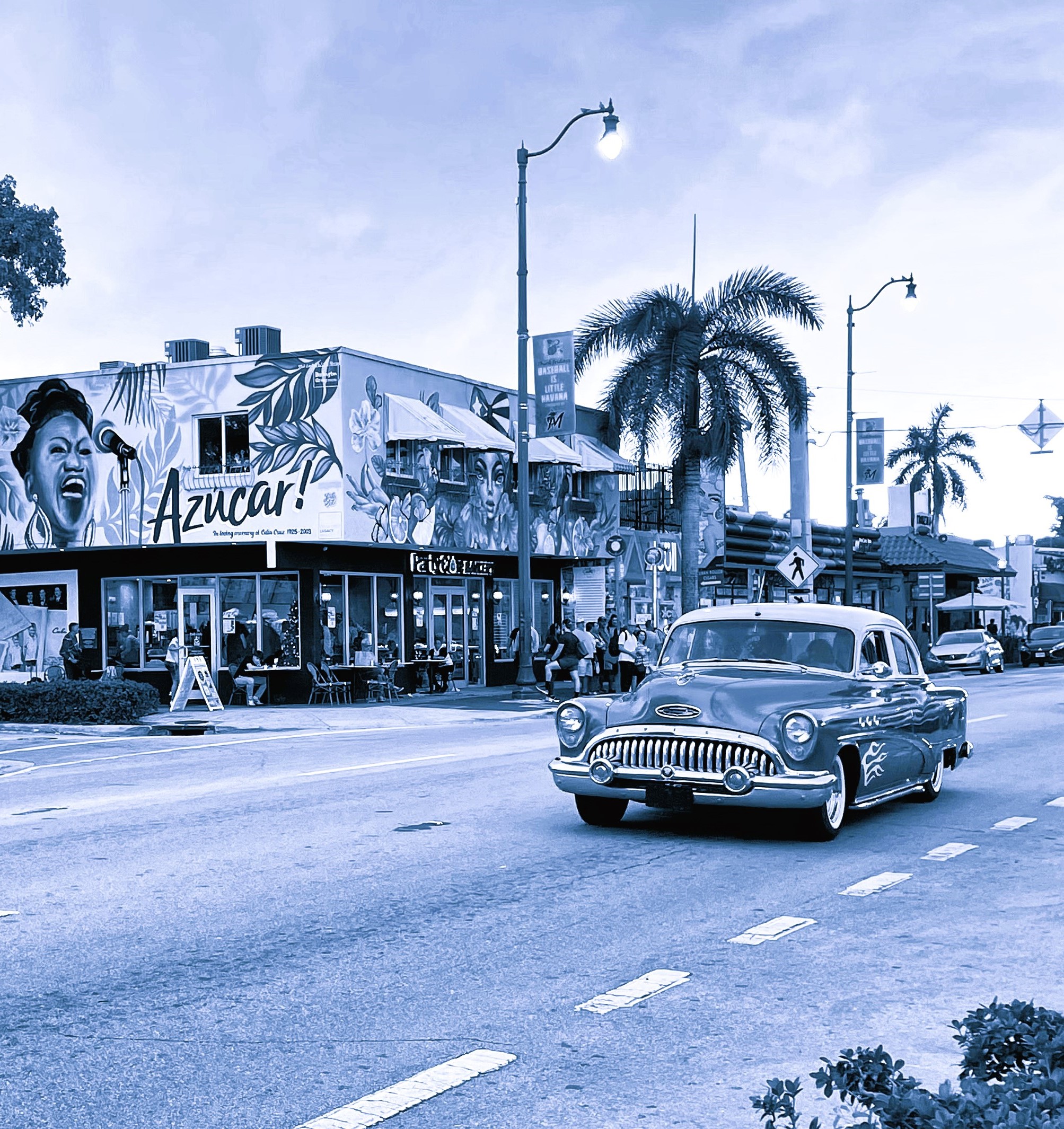 A very representative photo of Little Havana, with its bustling streets as an old chevy passes by.