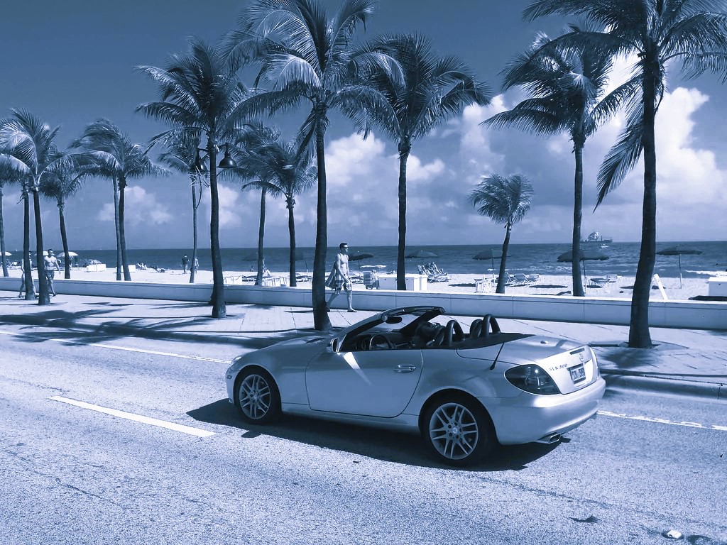 A car parked on the beach in Miami, representing its many transportation options among which is a car rental.
