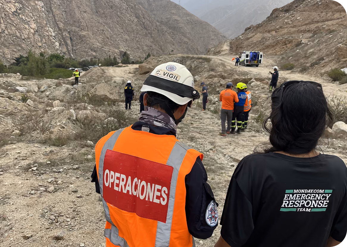 Rescue workers wearing safety gear and high-visibility clothing stand on a rocky mountainous terrain near an ambulance, coordinating emergency response efforts. This image was taken on Jamaica hurricane on 2025.
