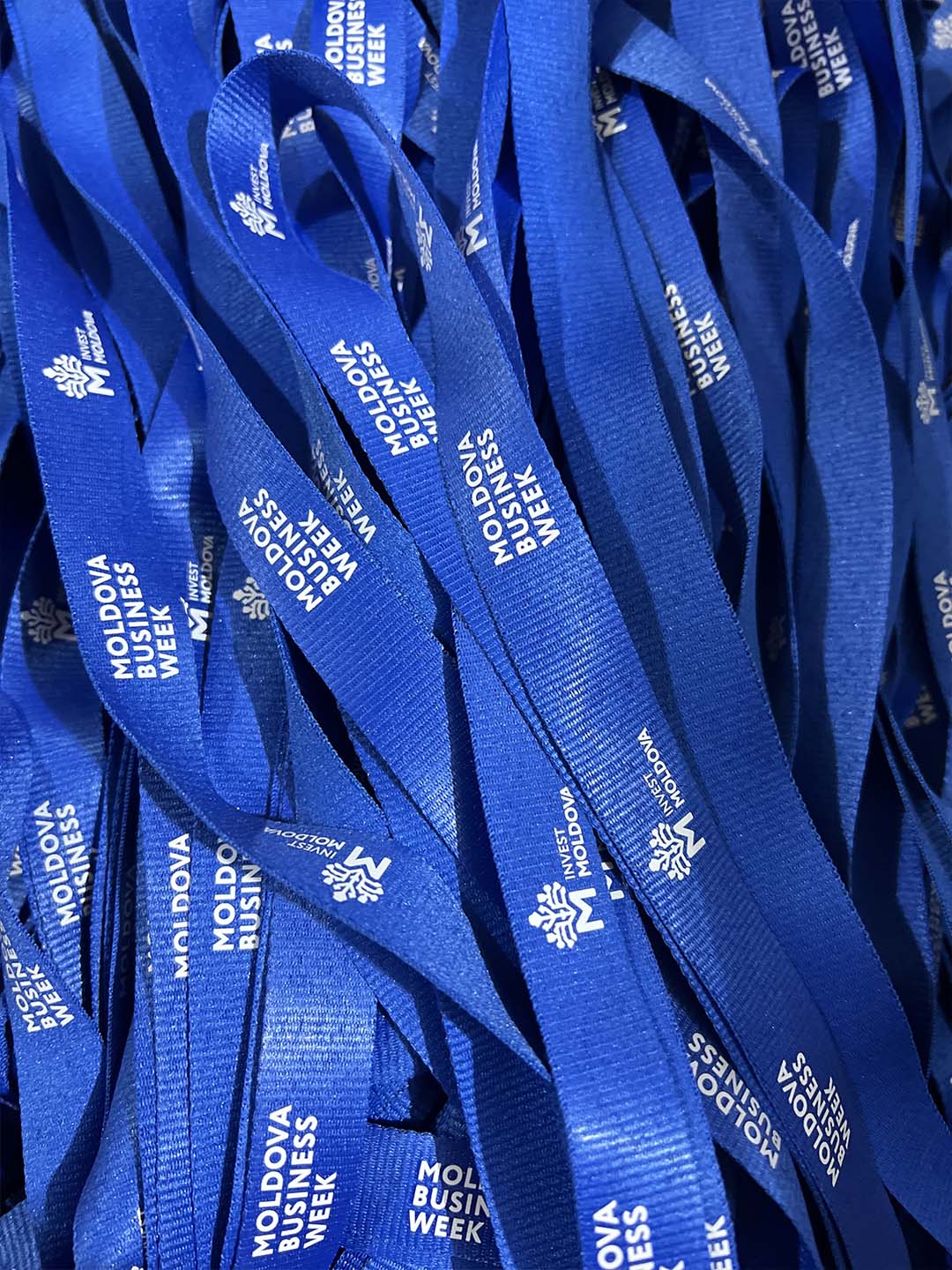 Синие ленты с белой надписью Moldova Business Week и логотипом Invest Moldova.