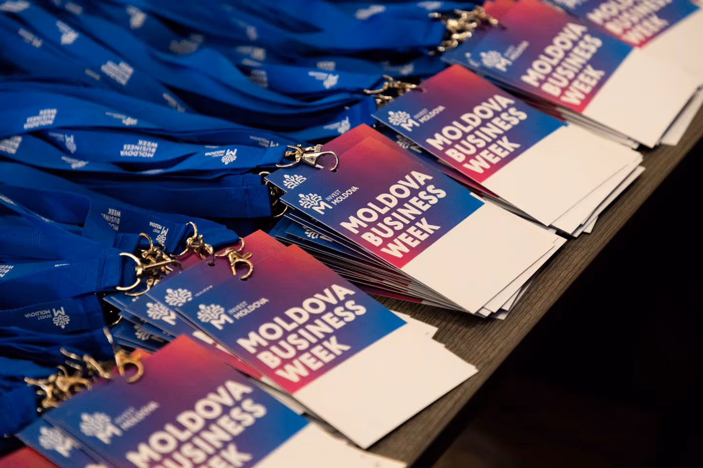 На столе лежат синие ленты с бейджами участника Moldova Business Week.