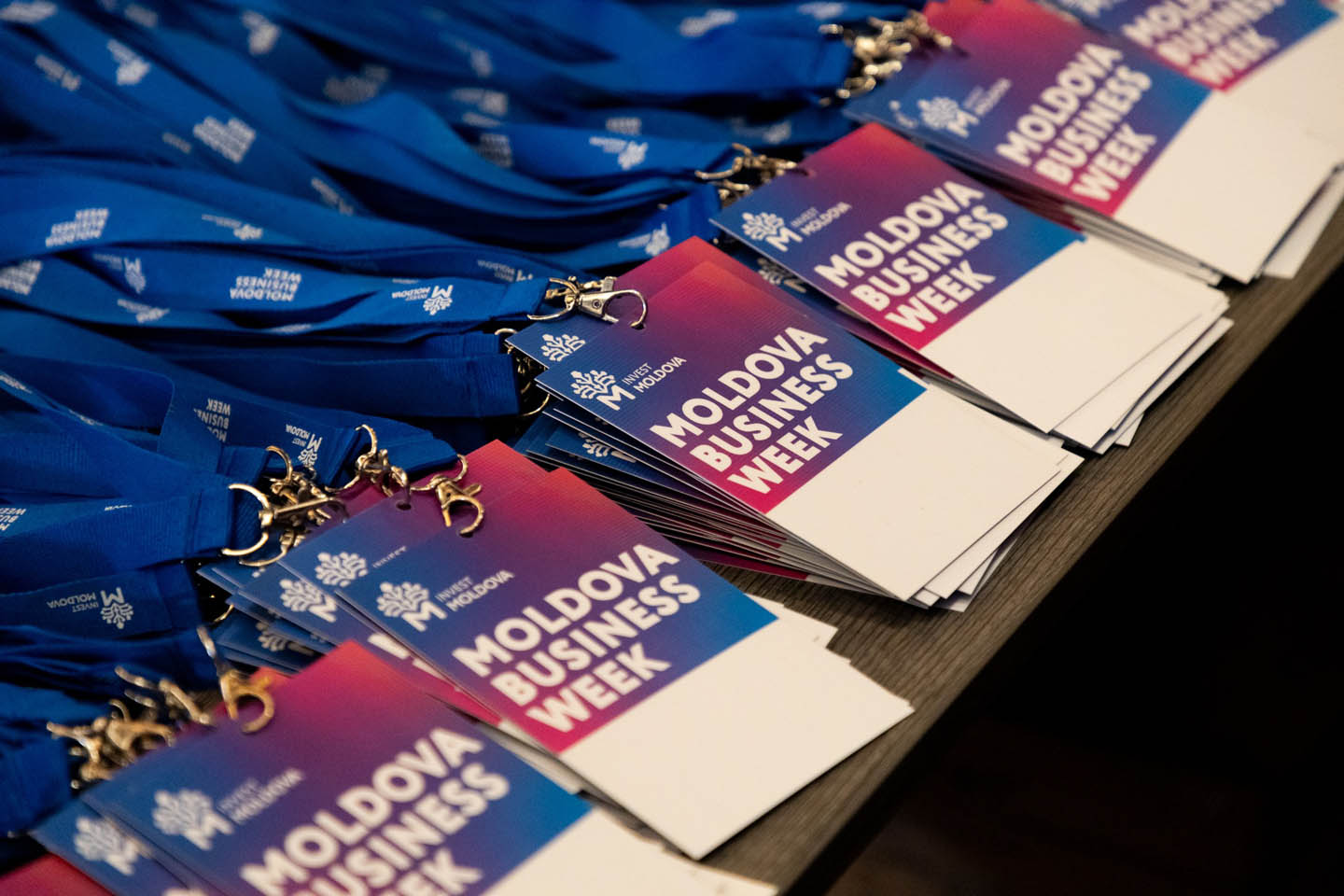 На столе лежат синие ленты с бейджами участника Moldova Business Week.