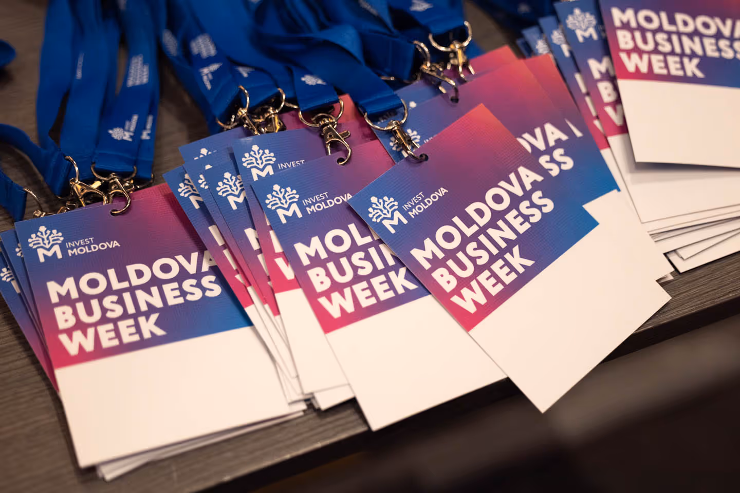 Бейджи с лого и названием Moldova Business Week на синем и розовом фоне с синими лентами.