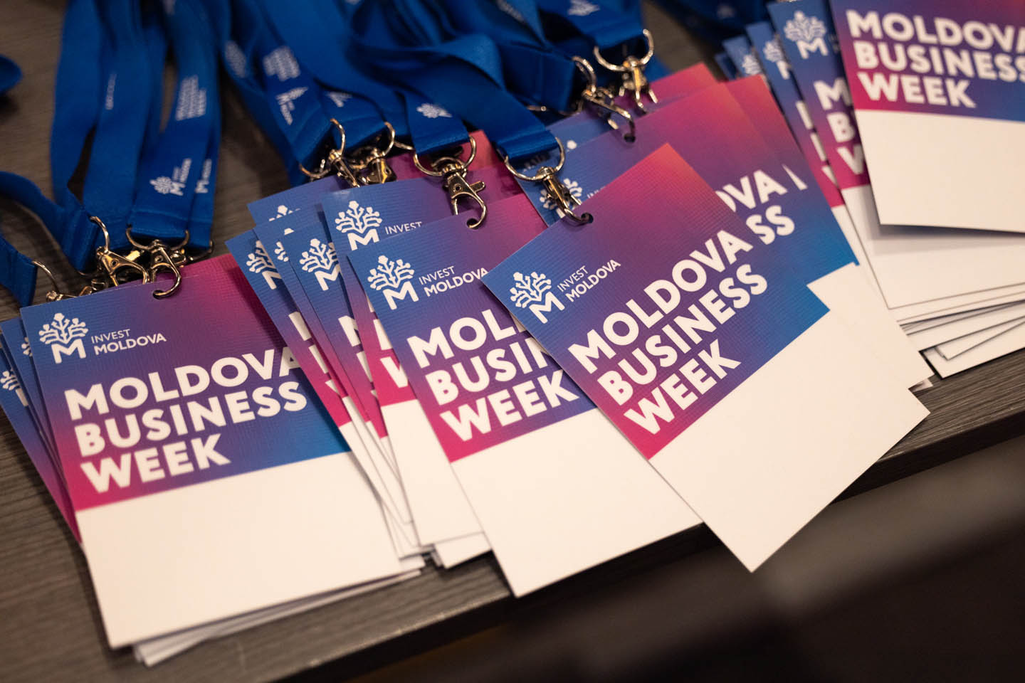Бейджи с лого и названием Moldova Business Week на синем и розовом фоне с синими лентами.