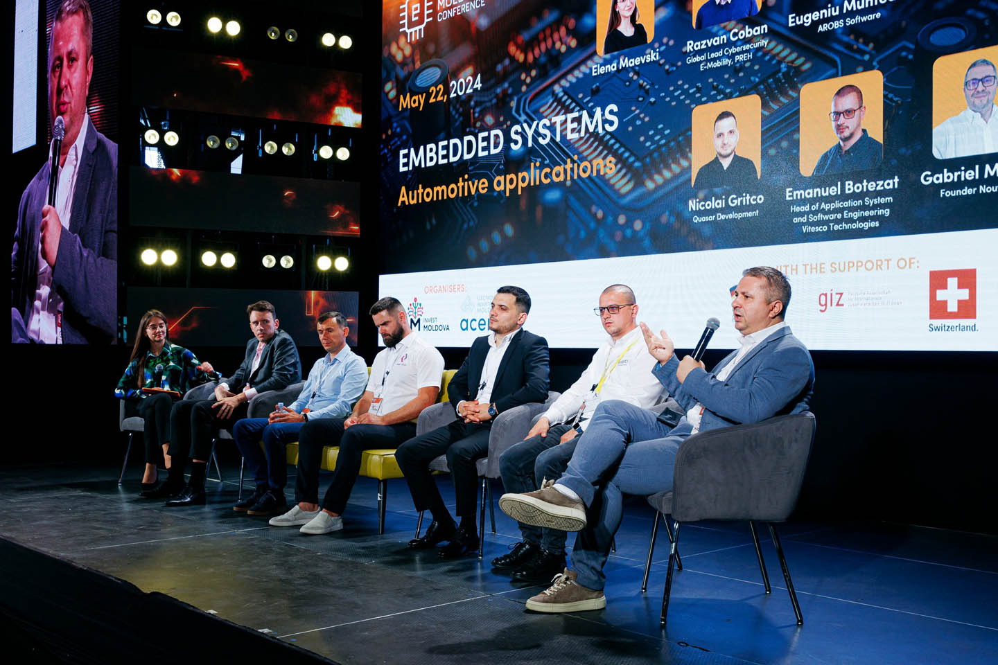 Панель экспертов из семи человек на сцене обсуждает встроенные системы и автомобильные приложения на конференции.