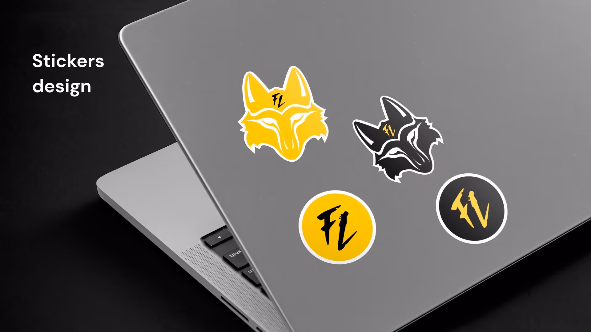 Серый ноутбук с четырьмя наклейками: две с силуэтом волчьей головы жёлтого и чёрного цвета, и две круглые с буквами FL жёлтого и чёрного цвета.