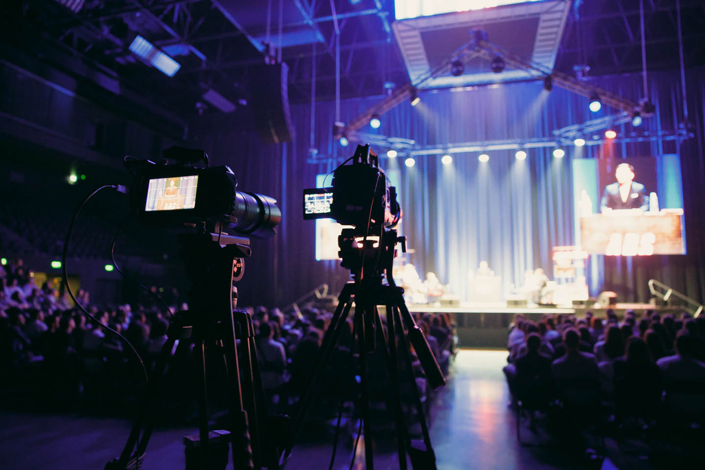 Зрители в зале мероприятия, организованного Media Show Group, аплодируют под сценическим светом от Line Production