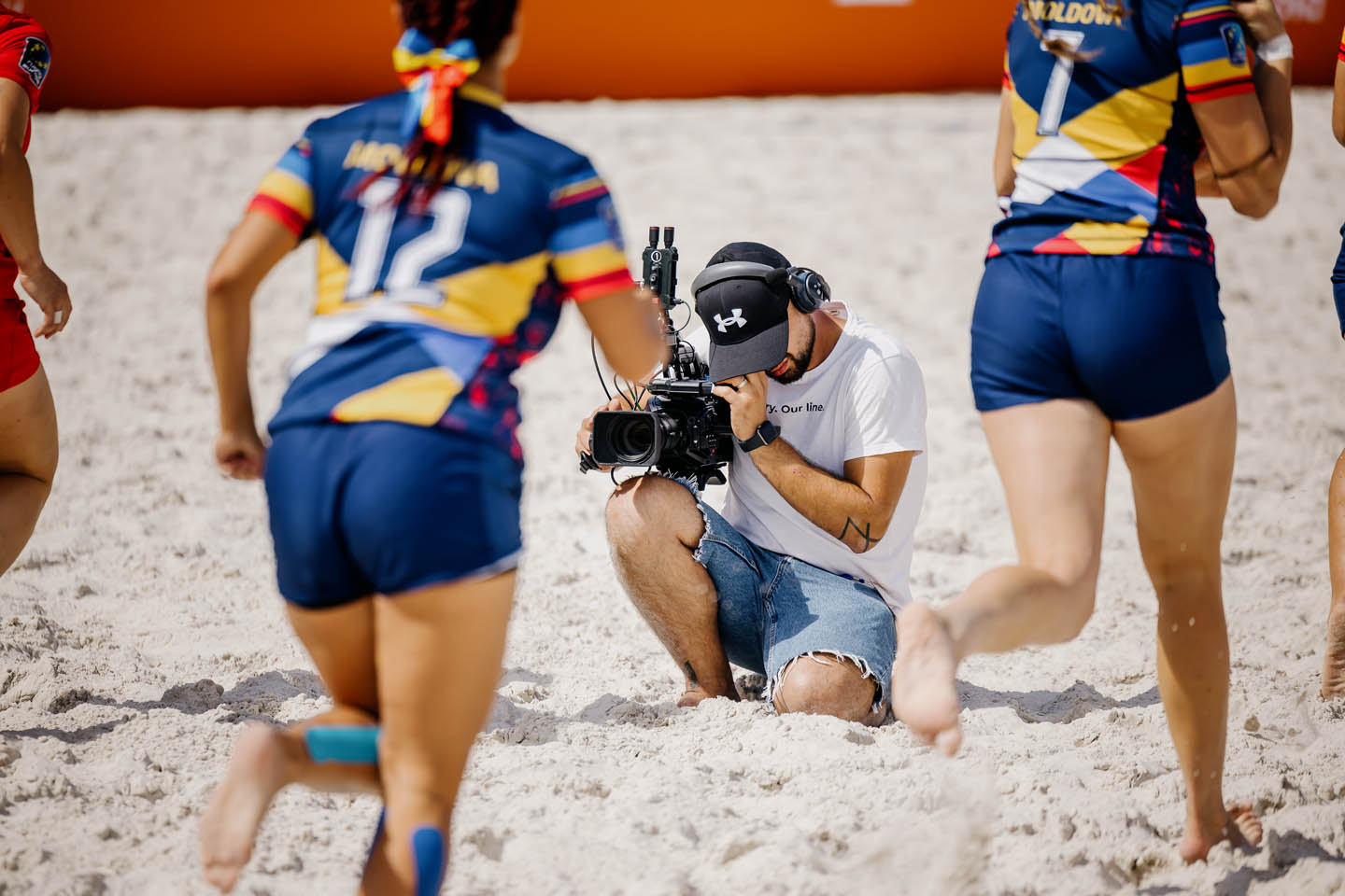 Игроки в действии на песчаном поле Rugby Europe Beach Championship в Chisinau 2025, с профессиональной трансляцией на экранах от MS-Prod под организацией Media Show Group.