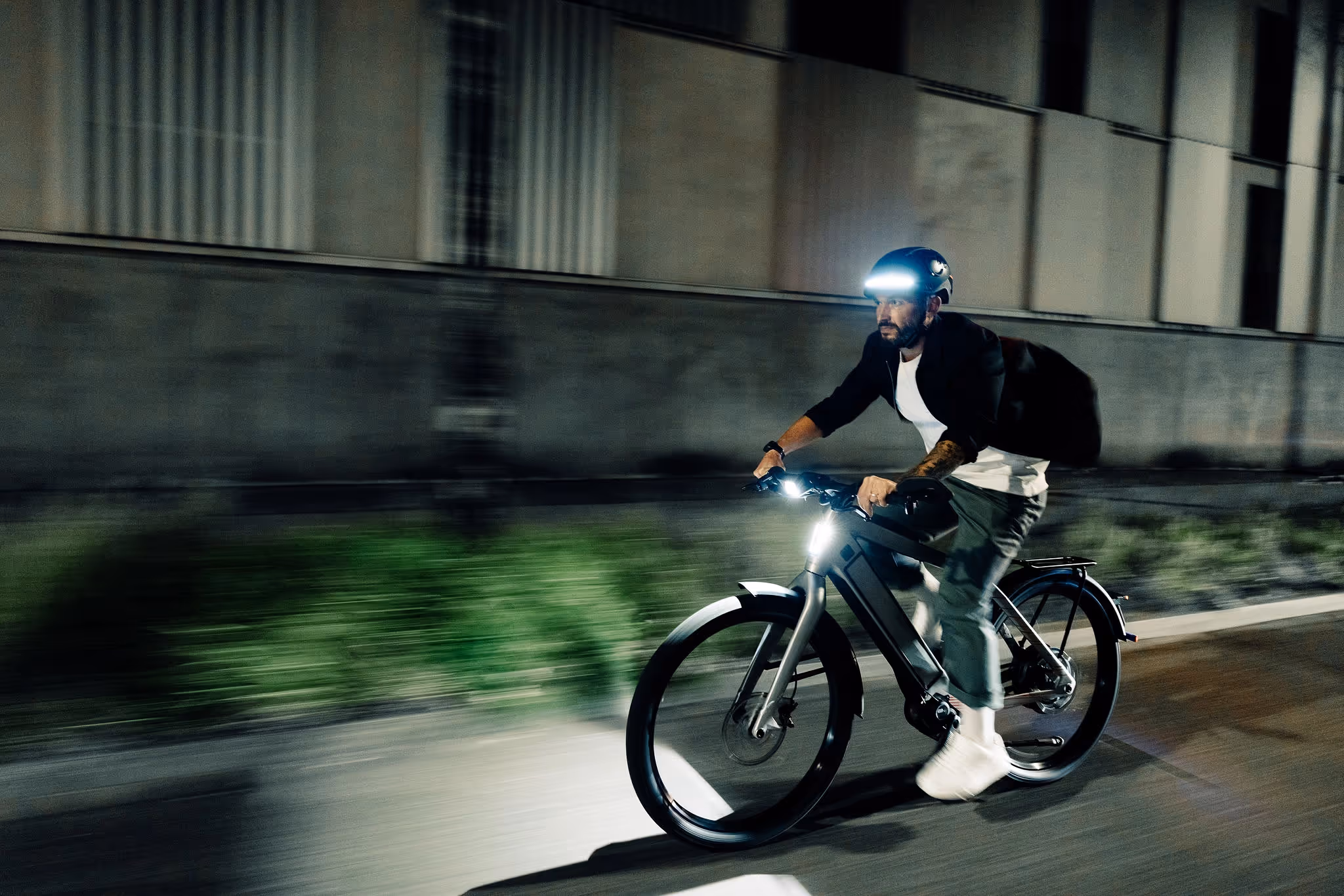 man rijdt op Stromer in het donker met veilige lichten op fiets en hoofd