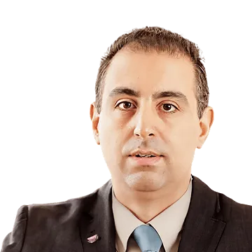 Portrait of a man in a dark suit, light shirt, and blue tie, looking directly ahead.