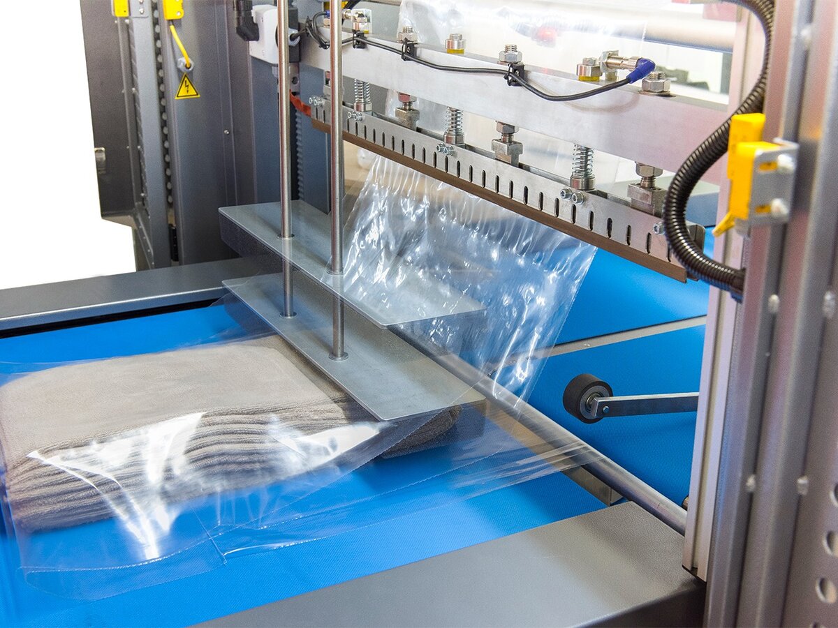Product being enclosed and sealed in shrink film by a sleeve wrapper