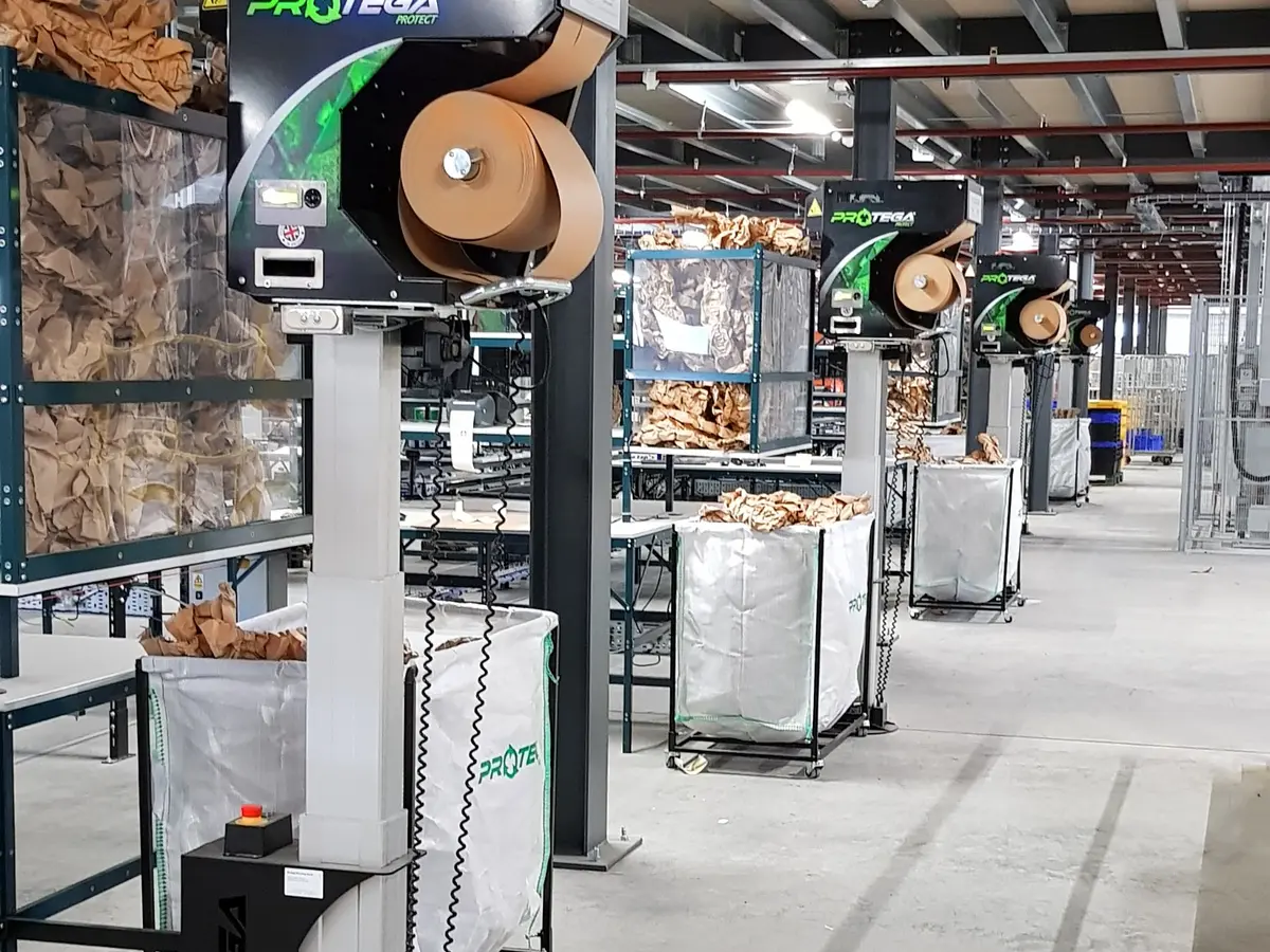 Multiple paper cushioning machines integrated along a packing line