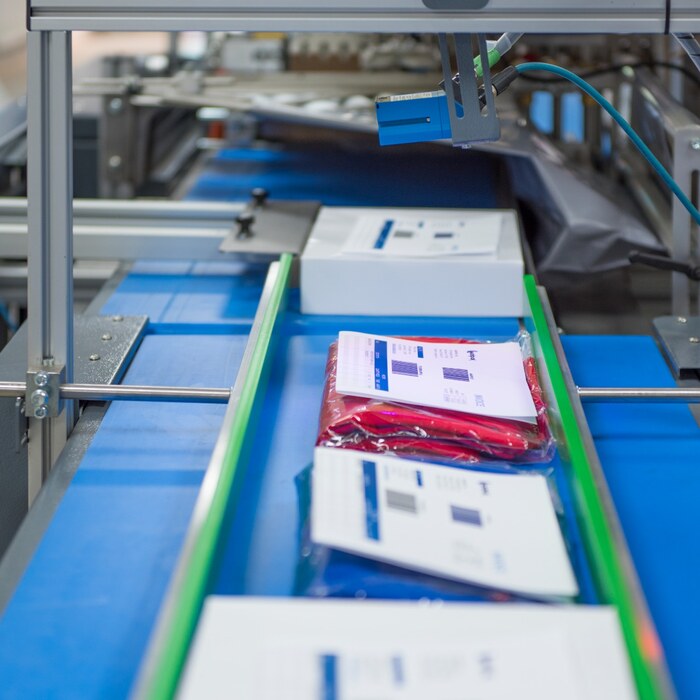 Film-wrapped e-commerce parcels travelling through an automated horizontal packaging system