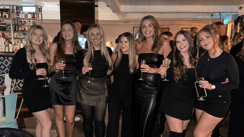 Radiance team all standing together holding c.hampagne on a celebratory night out