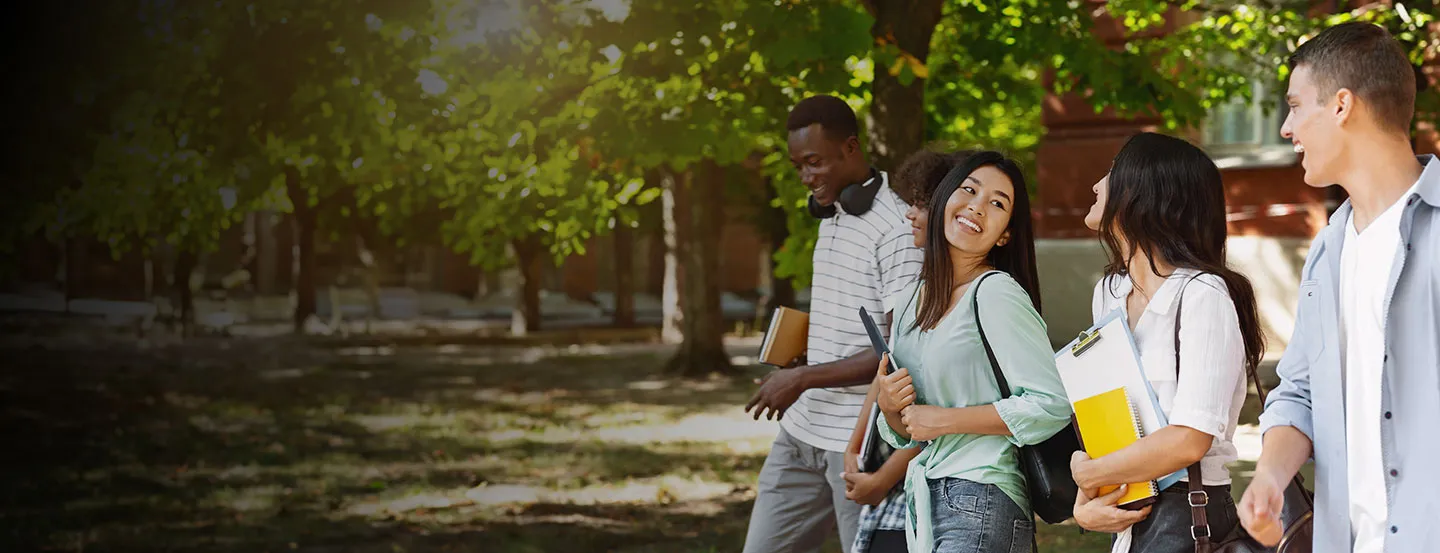 group of four college students walking together on campus