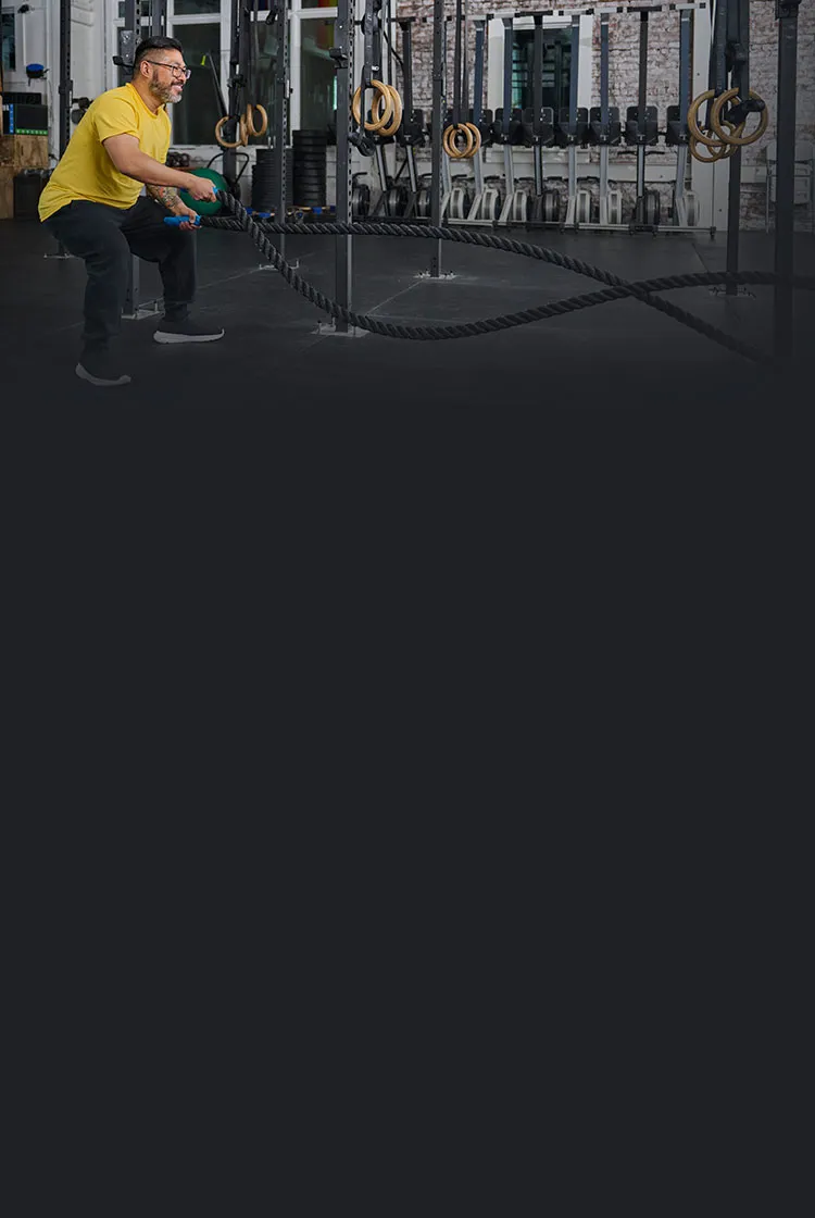 Man using weighted ropes at gym