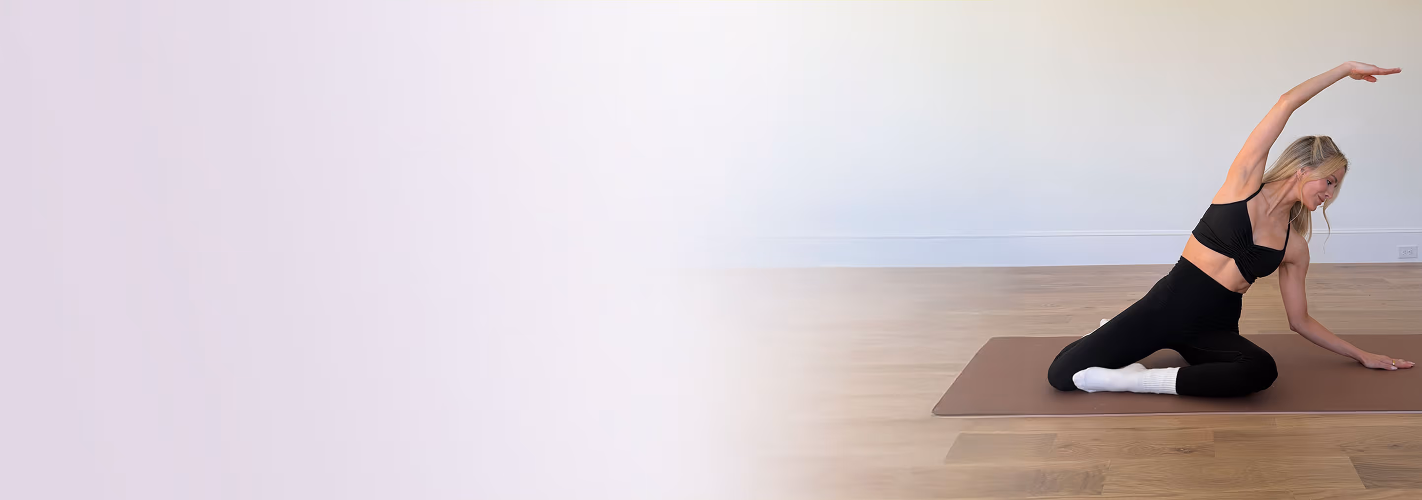 Andrea Rogers demonstrating stretch while seated on mat
