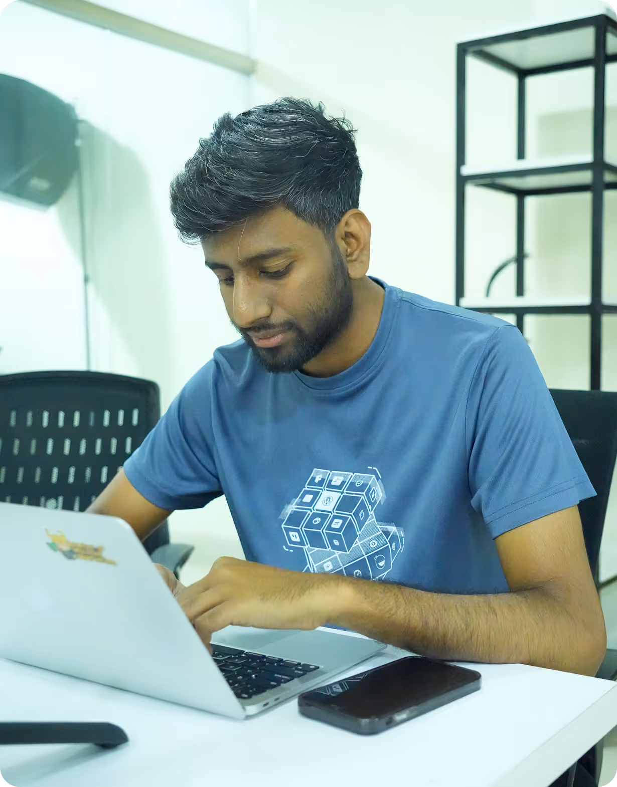 A man sitting at a table using a laptop computer.