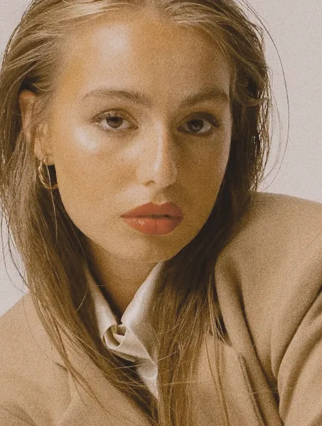 a close up portrait of women with red lipstick wearing a Lutea wool camel jacket and a silk blouse 