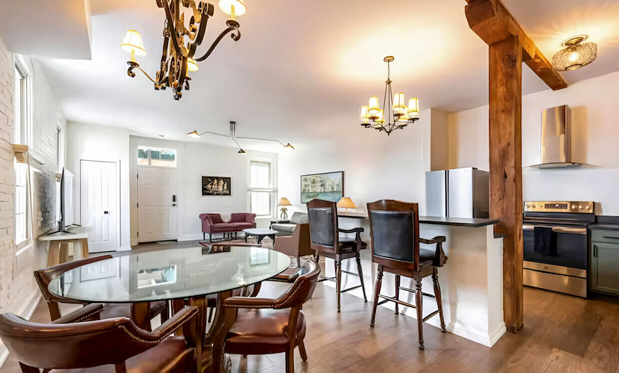 A kitchen with a table, chairs and a refrigerator.