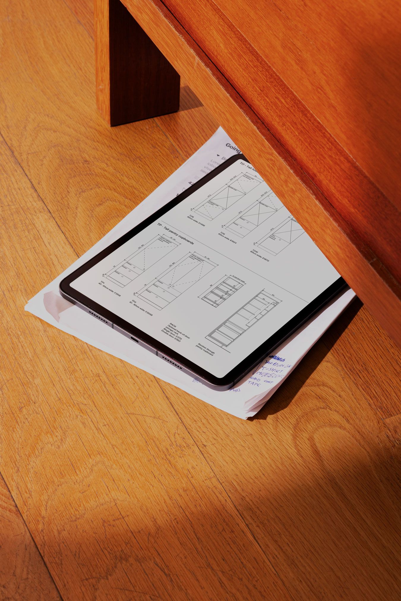 The Core guide shown on an iPad, resting on the the floor beneath a chair on top of hand written notes on paper.