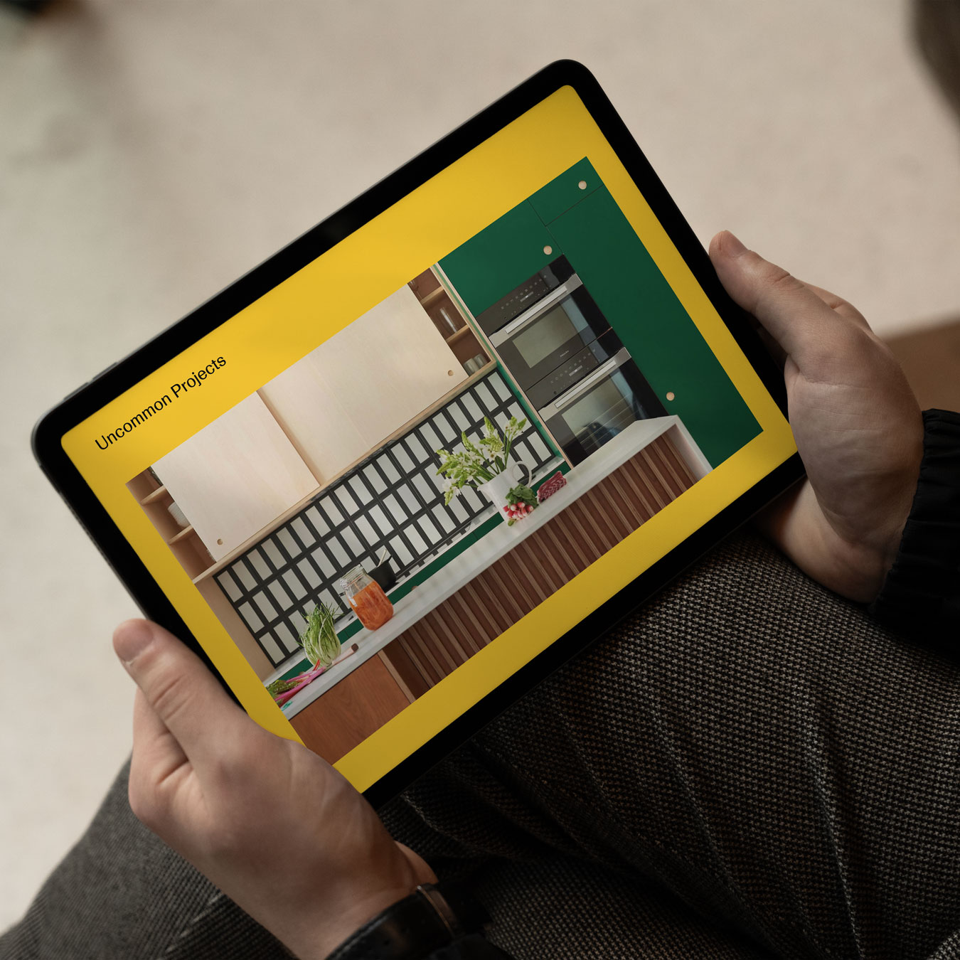 The digital brochure on an iPad screen being held in two hands.